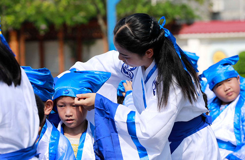 老师给新生整理衣冠。