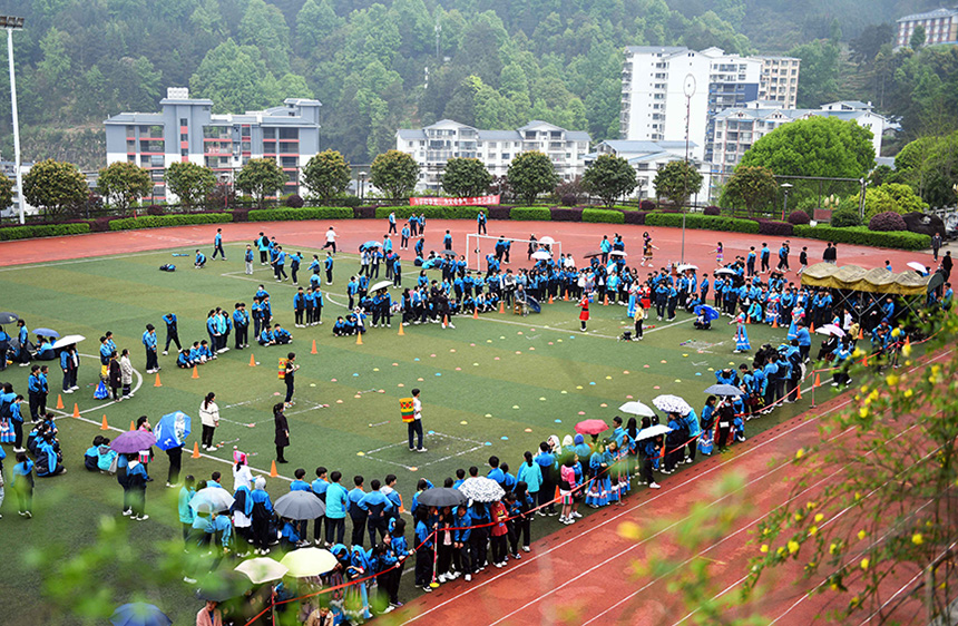学生在参加背篓投绣球比赛。
