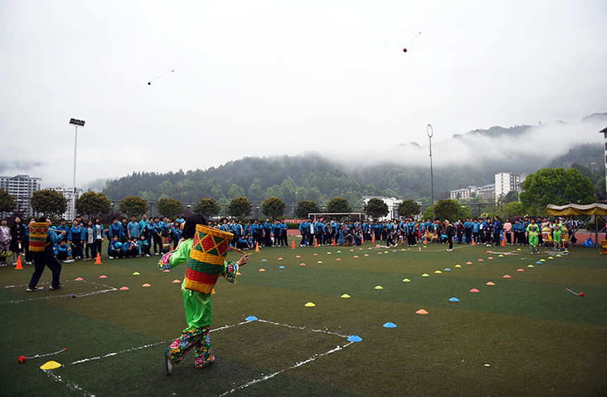 学生在参加背篓投绣球比赛。