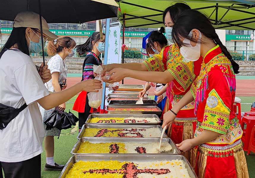 学生品尝糯米饭。