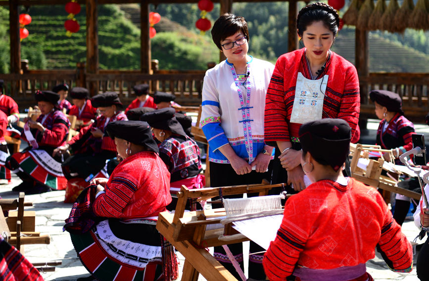 青年党员在向网友介绍当地瑶族服饰传统制作工艺。潘志祥摄  