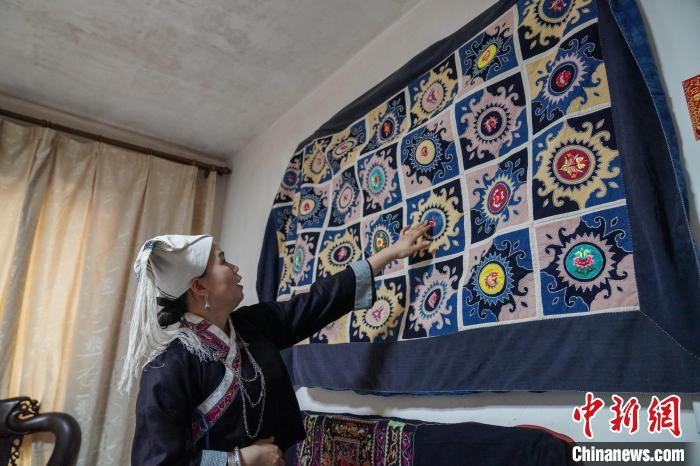 黄碧瑜将背带的主要图案,缝制在一张床单上展示。 王以照 摄