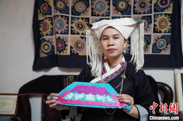 制作隆林壮族背带时,图案先设计成剪纸,再在剪纸的基础上缝制纹样。 王以照 摄