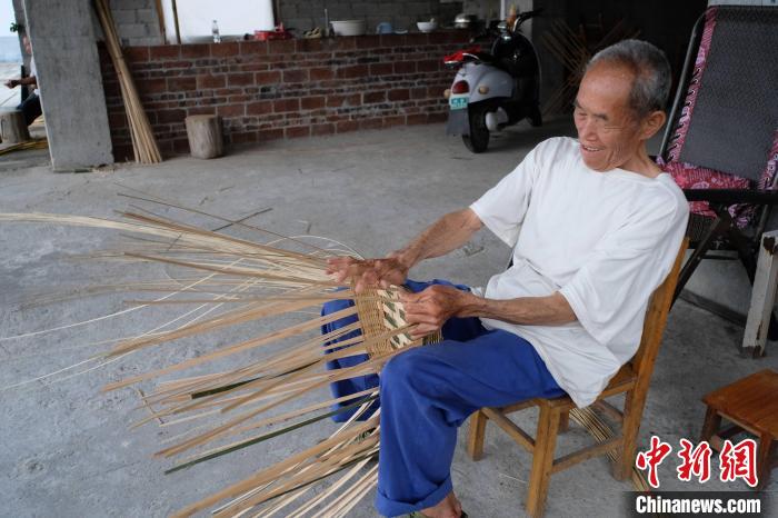 竹编匠人正在编织竹筐。　刘俊聪 摄