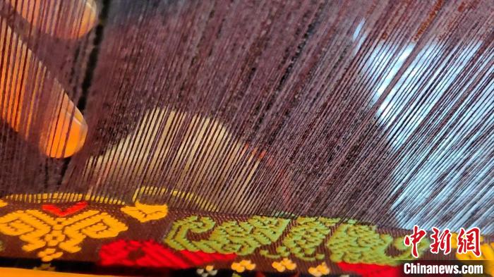 图为“织女”们用竹笼机织壮锦。　张广权 摄