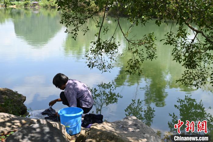 旧州景区内,一位妇女在河边洗衣。 王以照 摄 旧州景区内,一位妇女在河边洗衣。 王以照 摄