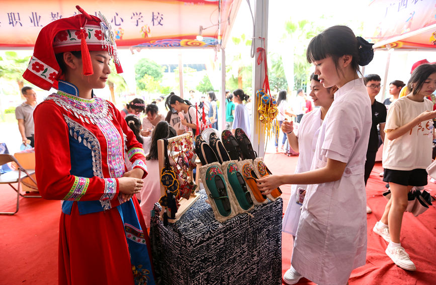 广西工贸职业技术学校学生展示民族风手工布鞋。罗仁维摄