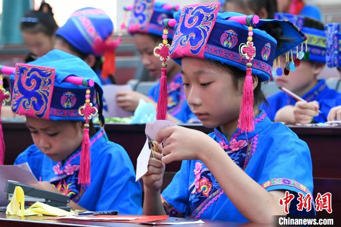 图为学生在学习仫佬族剪纸技艺。 廖光福 摄 图为学生在学习仫佬族剪纸技艺。 廖光福 摄