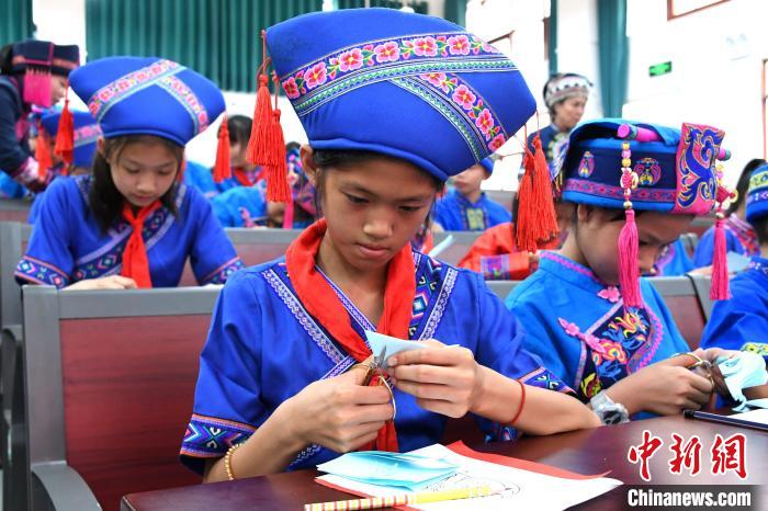 图为学生在学习仫佬族剪纸技艺。 廖光福 摄 图为学生在学习仫佬族剪纸技艺。 廖光福 摄