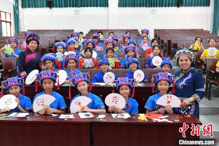 图为学生们在展示自己的仫佬族剪纸及文创作品。 廖光福 摄 图为学生们在展示自己的仫佬族剪纸及文创作品。 廖光福 摄