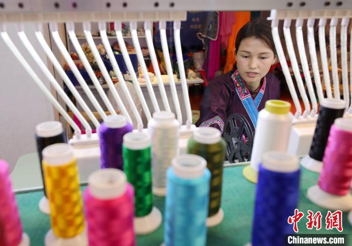 1月4日,一名绣娘在广西三江侗族自治县古宜镇一家服饰馆生产绣片。龚普康 摄